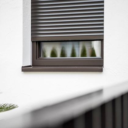 Ein Fenster mit Standard-Rollläden und Fensterbank für den Außenbereich