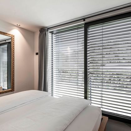 La camera di un albergo con finestre frameless e frangisole