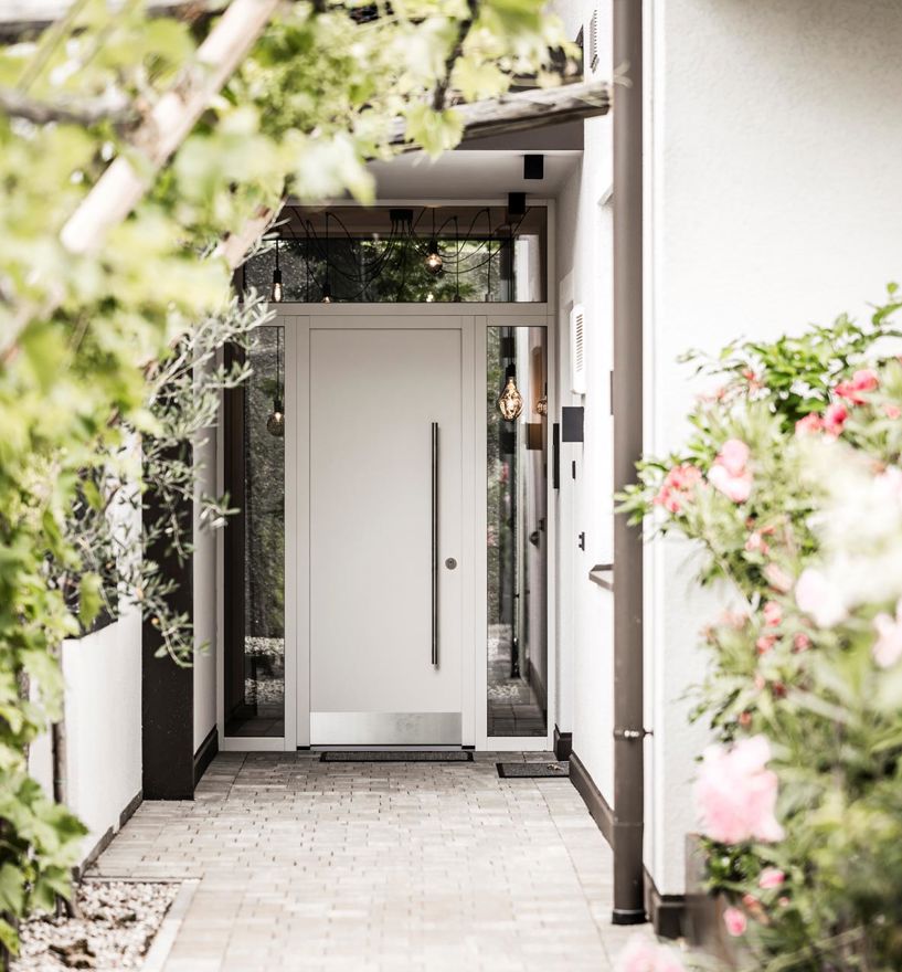 Eine Haustür, die von Glaselementen umfasst wird