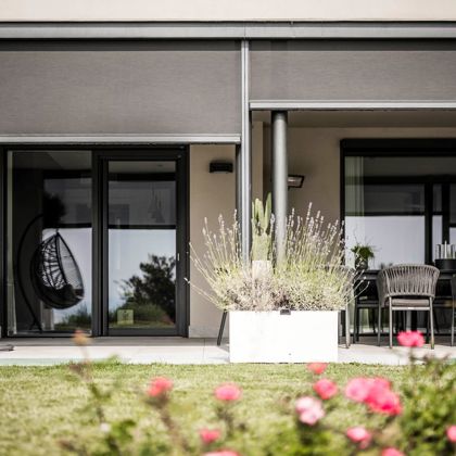 Una terrazza con tende oscuranti con guida zip