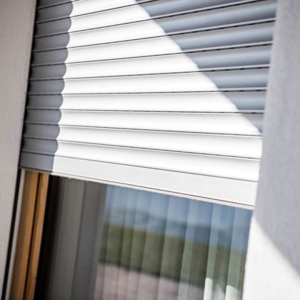 Una finestra con avvolgibili standard abbassate a metà